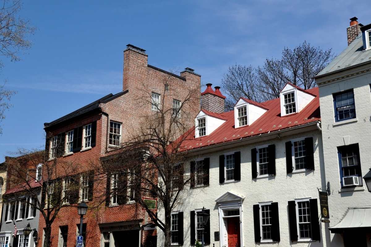 old brick and white colonial townhomes in city street