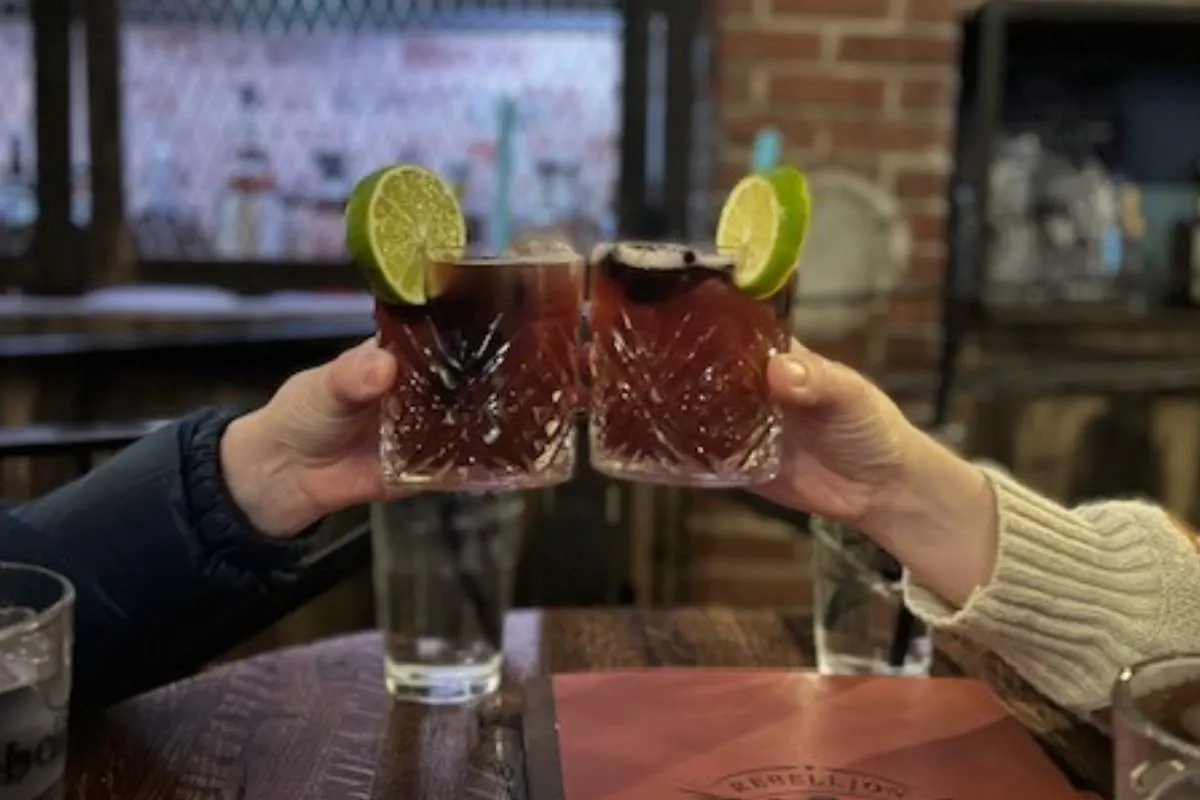 two women holding whiskey cocktails