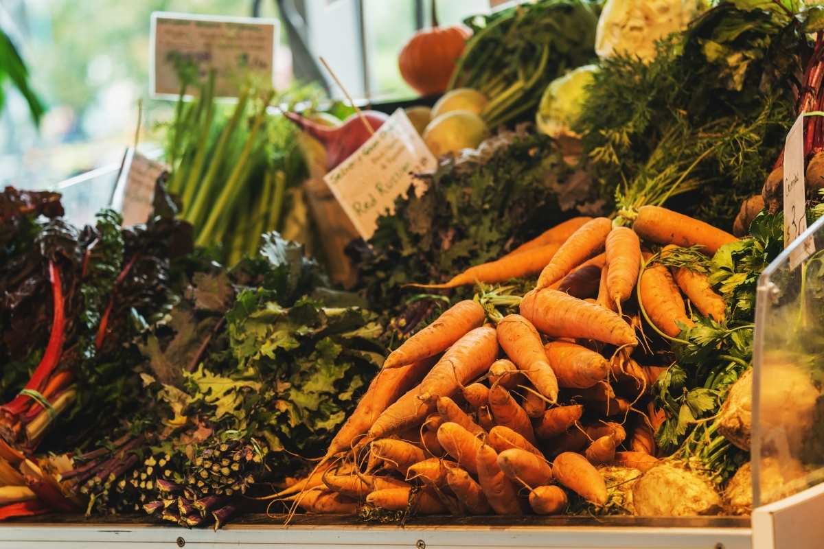 display of fresh carrots and green at farmers market