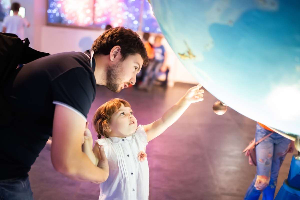 child and dad looking at space exhibit