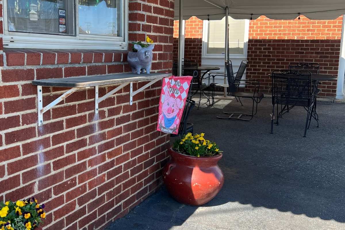 brick building with awning and outdoor tables