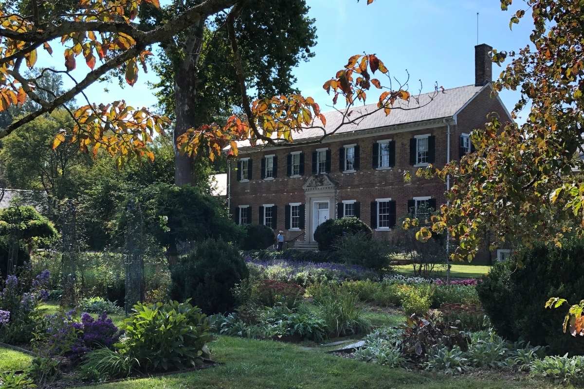 brick manor house behind trees