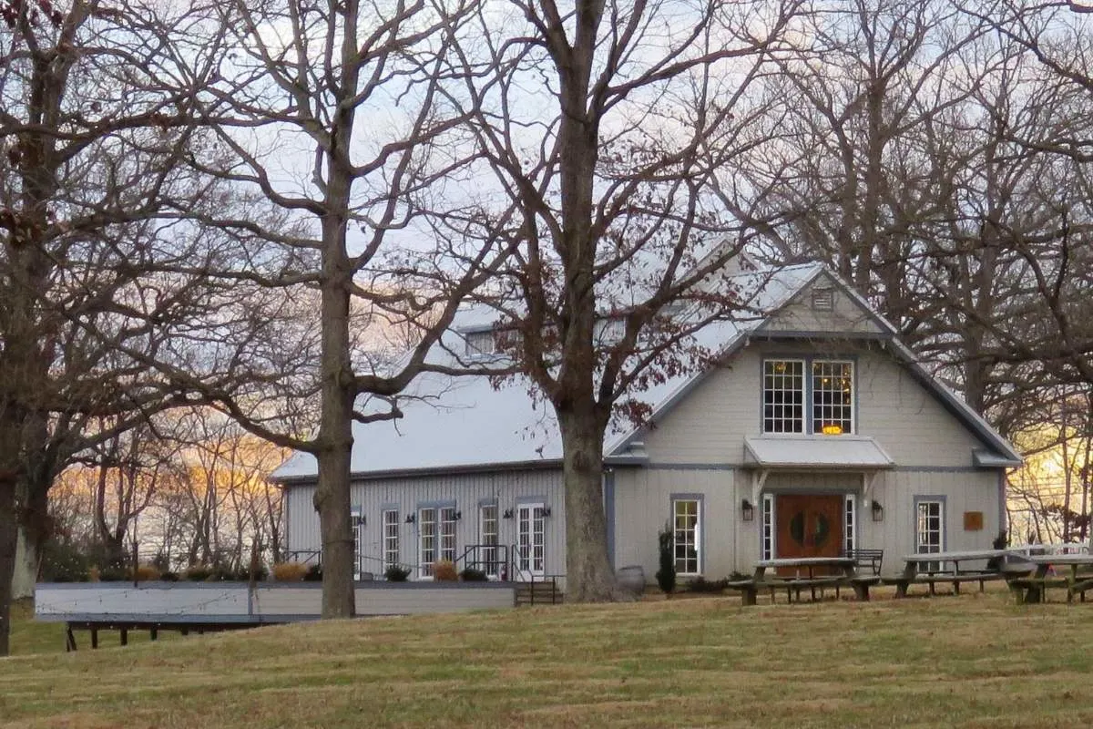 gray barn with lots on windows on hill