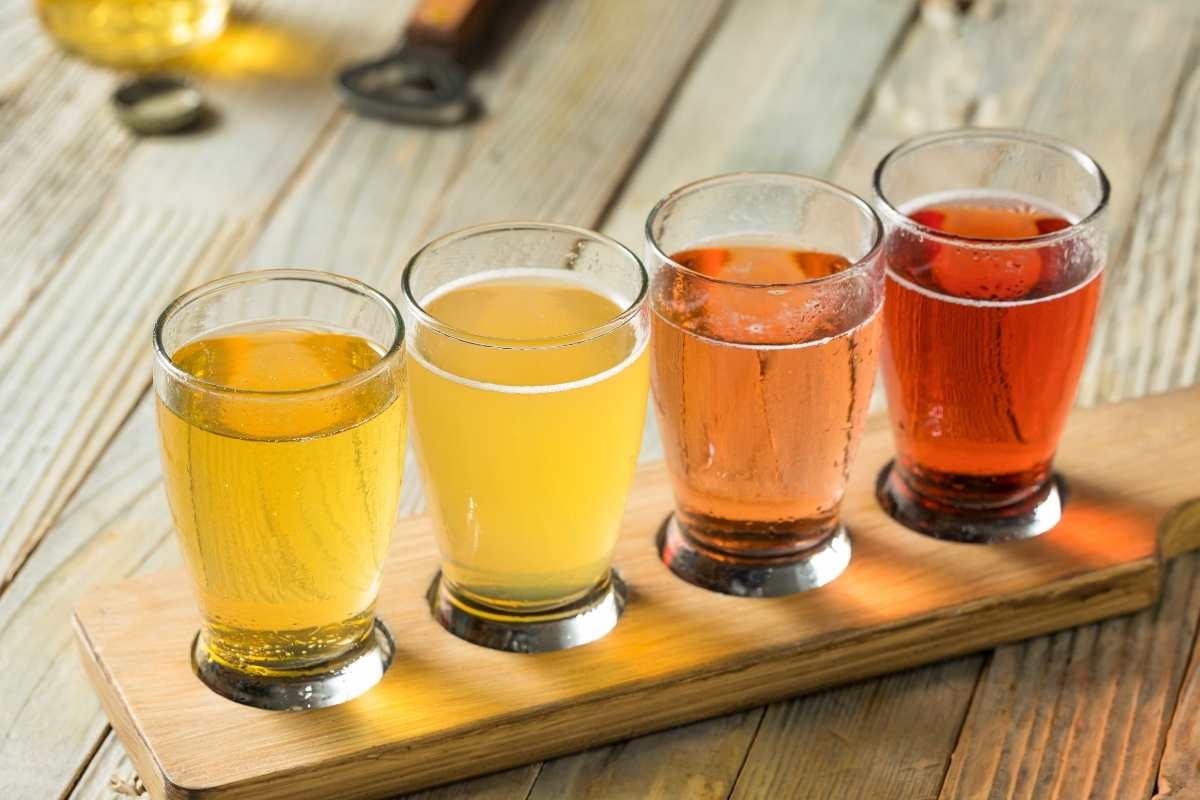 4 glasses of hard cider on wooden table