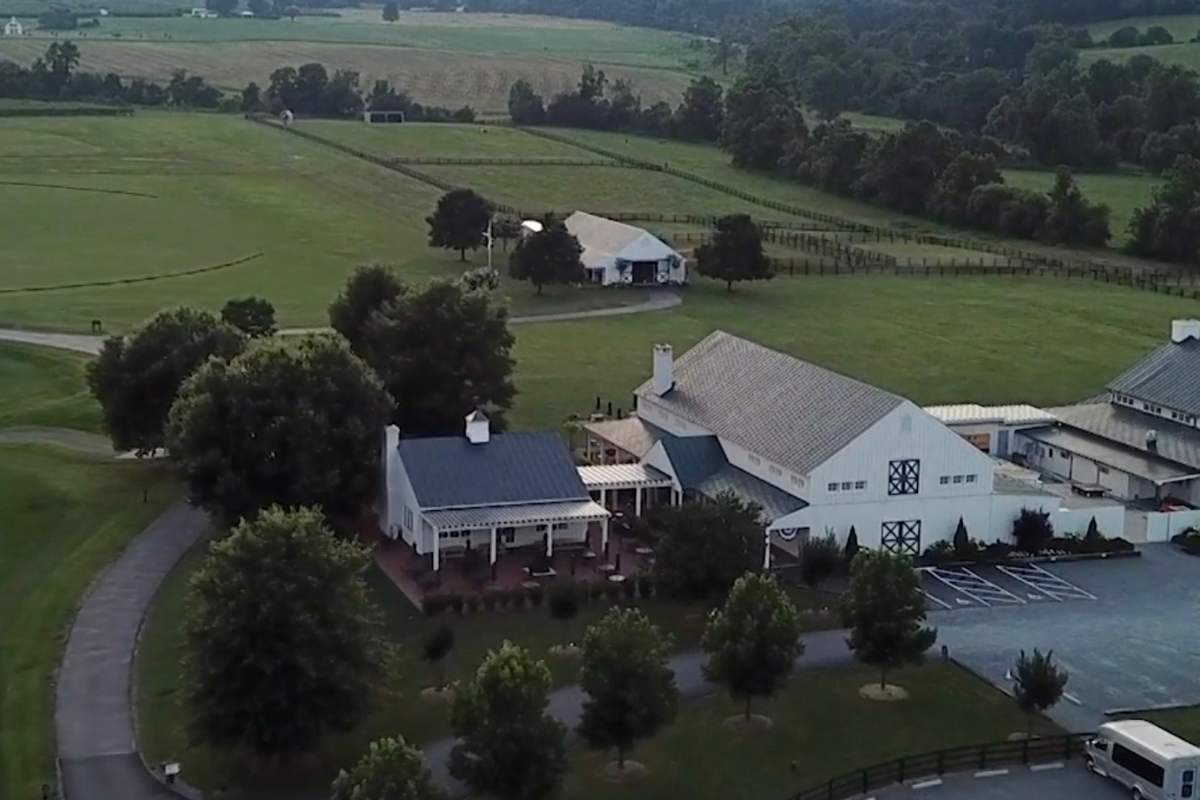 overhead view of white barn and green fields 