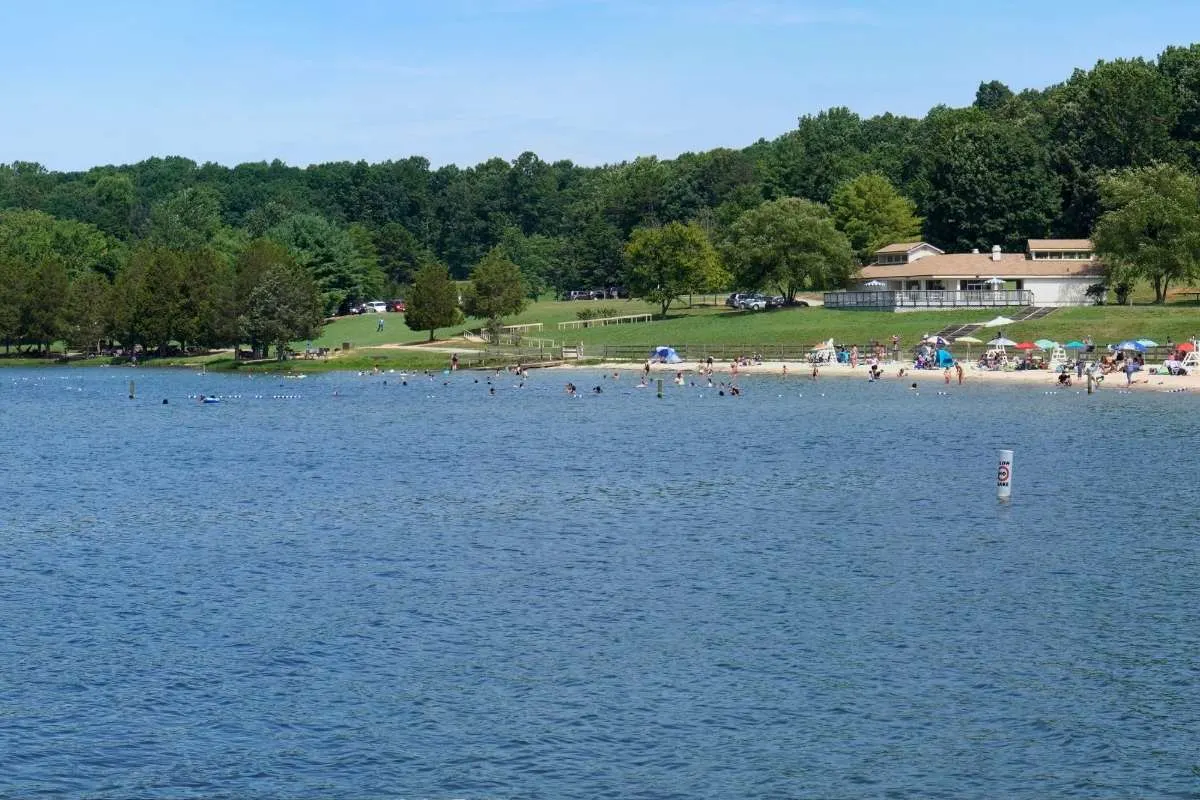 lake with small beach and building on shore