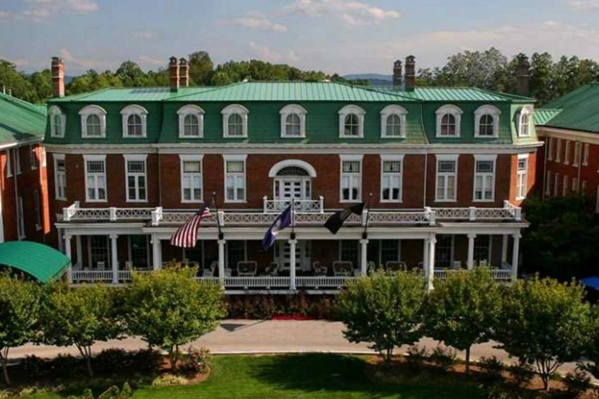 large brick home with green room and white trim