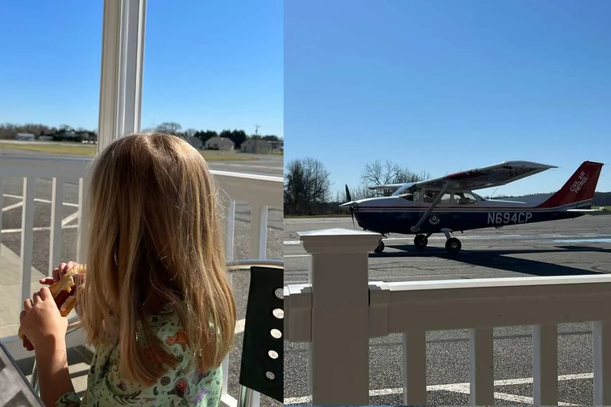 little girl eating lunch outside next to airplane