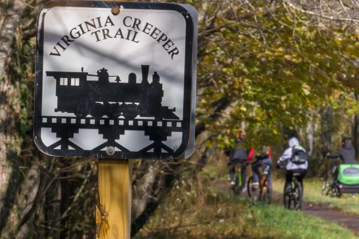 sign for virginia creeper trail with bikers in background