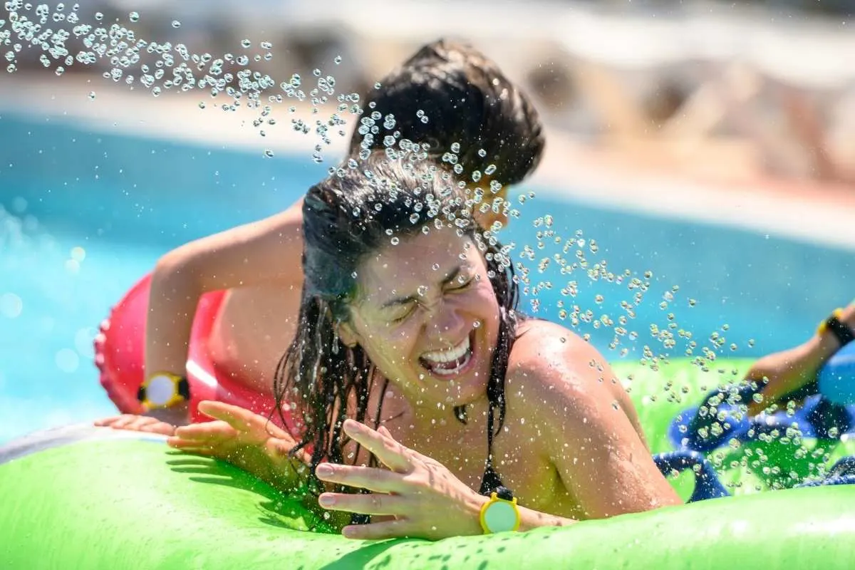 woman on green tube at bottom of waterslide
