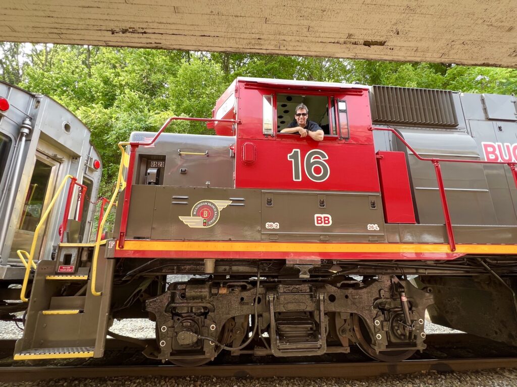 A man is sitting on a train, traveling to Staunton.