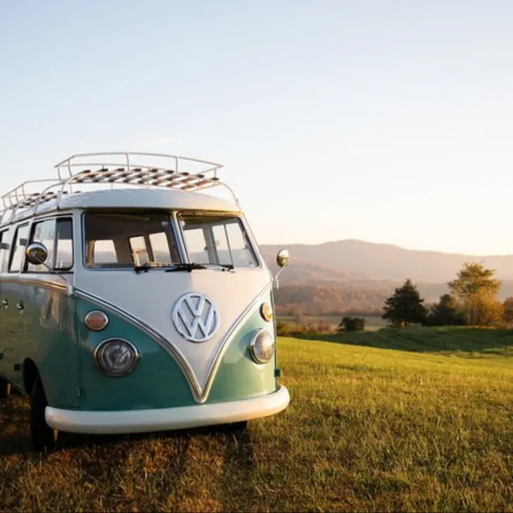 A vintage vw bus parked in a grassy field.