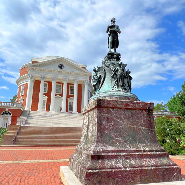 A statue of a man in front of the University of Virginia.