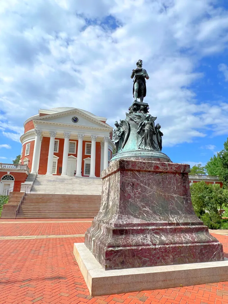 A statue of a man in front of the University of Virginia.