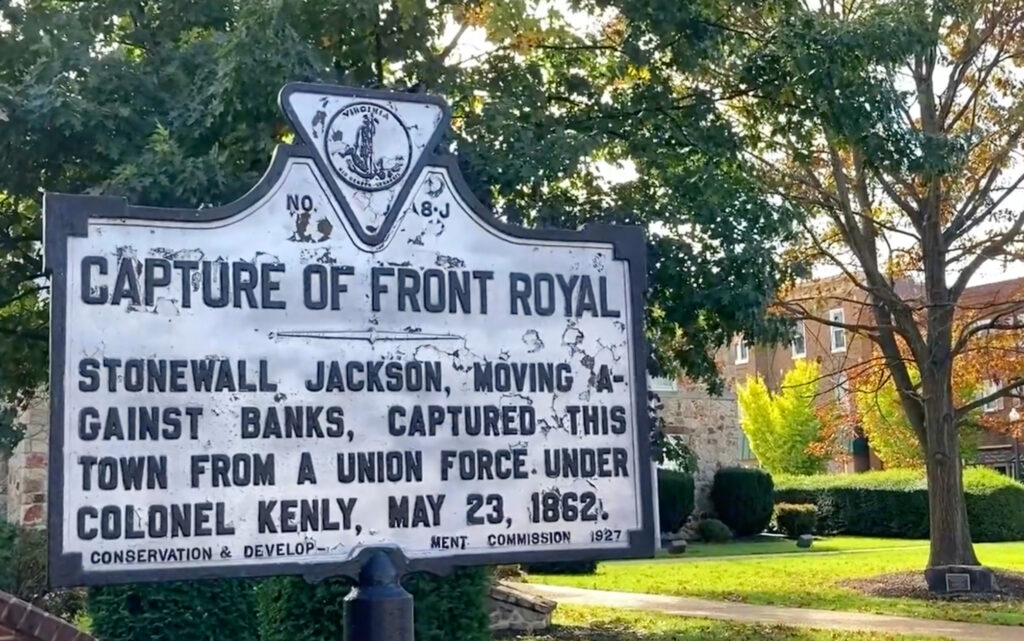 Historical marker describing the capture of Front Royal, Virginia by Stonewall Jackson from Union forces under Colonel Kenly on May 23, 1862. Trees and a building are visible in the background, highlighting the historic landscape of Front Royal.