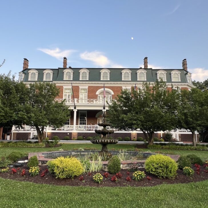 exterior of The Martha Washington Inn featuring a fountain and gardens in front of the historic brick hotel