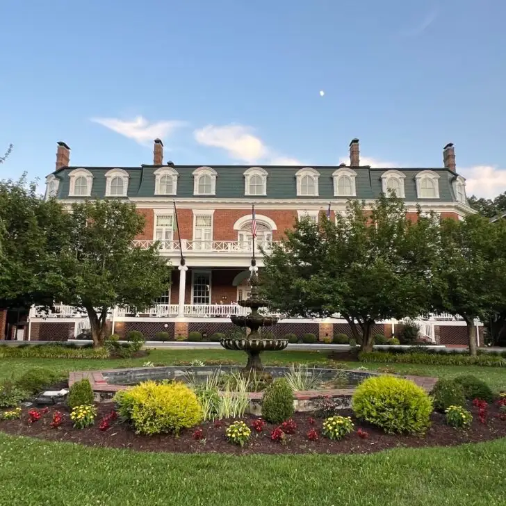 exterior of The Martha Washington Inn featuring a fountain and gardens in front of the historic brick hotel